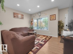 Living area with light wood-finish flooring, recessed ceiling lighting, and neutral wall tones - 
