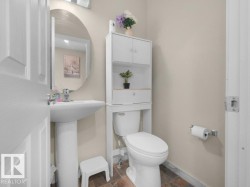 Pedestal sink with a chrome faucet and an oval wall-mounted mirror - 