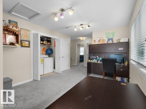 Dedicated laundry area with bi-fold doors, track lighting, ceiling fan, and carpeted flooring - 1419 27 Av, Edmonton, AB 