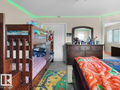 Bedroom featuring carpet flooring and a neutral color palette - 1419 27 Av, Edmonton, AB 