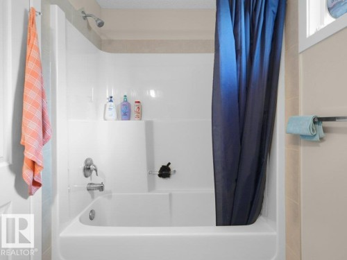 Shower-bathtub combination with bright white surround and integrated shelving - 1419 27 Av, Edmonton, AB 
