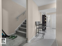 Carpeted staircase with white handrail and base trim - 