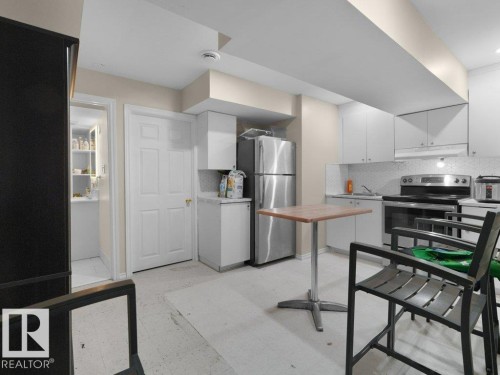 Kitchen featuring stainless steel appliances, white cabinetry, and a tile backsplash - 1419 27 Av, Edmonton, AB 