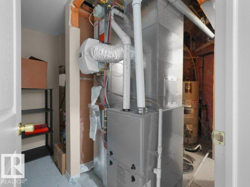 Dedicated utility space featuring a furnace and water heater - 1419 27 Av, Edmonton, AB 