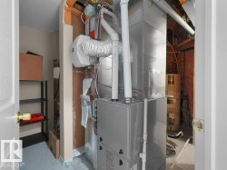 Dedicated utility space featuring a furnace and water heater - 
