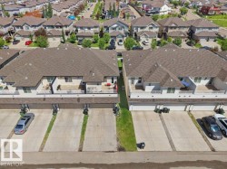 Aerial perspective showcasing townhome properties with attached garages, individual parking spaces, and second-story balconies - 