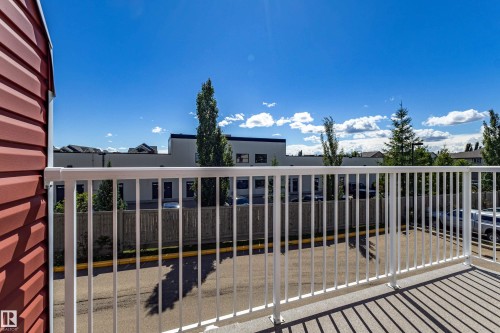 Private exterior balcony with white railing and red siding - 13 1816 Rutherford Road, Edmonton, AB 