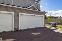 Two-car garage with panel-style doors and exterior lighting fixtures - 