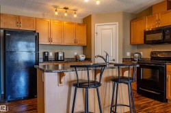 Kitchen featuring wood-finish flooring and light wood cabinetry - 