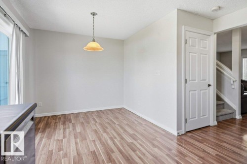 Dining area featuring wood-finish flooring, a pendant light fixture, and neutral wall tones - 30 1404 Hermitage Road, Edmonton, AB 