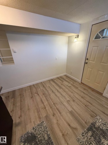 Light wood-finish flooring complements white walls and trim - 10220 107 Street, Westlock, AB - Indoor Photo Showing Other Room