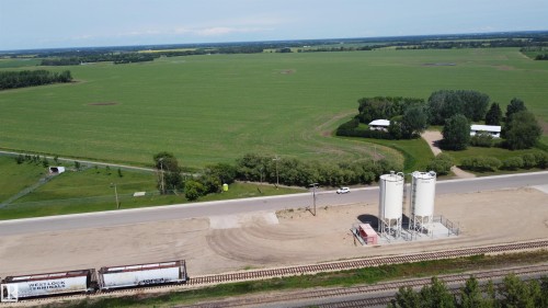 Industrial site featuring two large white storage silos on a concrete pad with surrounding gravel - 10220 107 Street, Westlock, AB - Outdoor With View