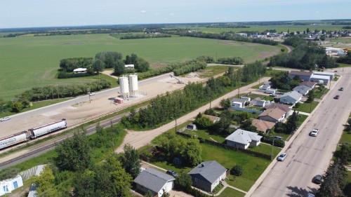 Aerial perspective showcasing a residential area, agricultural fields, and a commercial site - 10220 107 Street, Westlock, AB - Outdoor With View