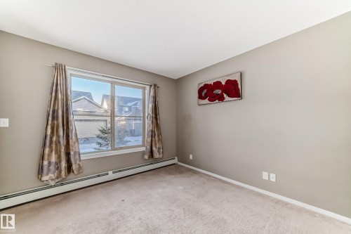 Room featuring neutral-toned carpeting, light gray wall paint, and white baseboards - 121 111 Watt Common, Edmonton, AB 