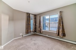 Carpeted interior space featuring a large window and a glass-paneled door - 