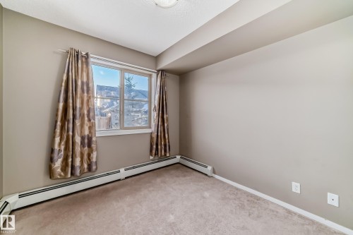 Room featuring wall-to-wall carpeting, light neutral wall paint, and baseboard heating - 121 111 Watt Common, Edmonton, AB 