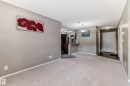 Open-concept living area with neutral carpeting and warm gray walls - 121 111 Watt Common, Edmonton, AB 