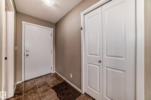 Entryway featuring a white paneled door, ceramic tile flooring, and a flush mount ceiling light - 121 111 Watt Common, Edmonton, AB 