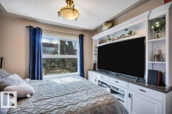 Built-in media center with open shelving, integrated lighting, and white cabinetry - 