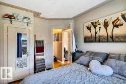 Interior room featuring crown molding, a built-in wall shelf, a door with an attached full-length mirror, and wood-finish flooring - 