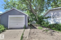 Detached garage with a gray exterior finish and a white garage door - 