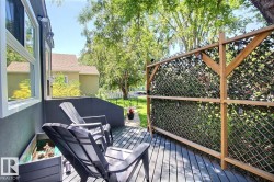Exterior deck featuring a wood-finish privacy screen with integrated lighting, wood-finish decking, and a built-in planter - 