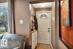 Entryway featuring a white paneled door with an arched glass insert, black hardware, and an overhead flush-mount light fixture - 