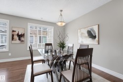 Dining area with light gray walls, wood-finish flooring, and white baseboards - 
