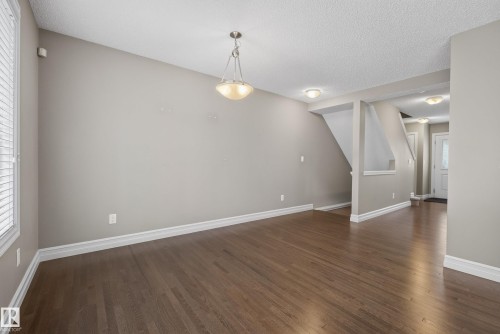Expansive interior featuring rich wood-finish flooring, neutral wall tones, and white trim - 53 3625 144 Avenue, Edmonton, AB 