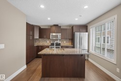 Kitchen featuring wood-finish flooring, recessed lighting, and a window with blinds - 