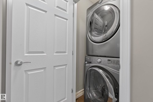 Space-saving stacked washer and dryer unit with a sleek silver finish and front-loading design - 53 3625 144 Avenue, Edmonton, AB 