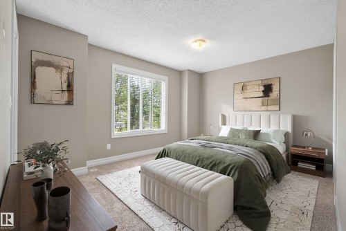 Spacious room featuring neutral paint, a large window, white trim throughout, textured ceiling, and carpet flooring - 53 3625 144 Avenue, Edmonton, AB 