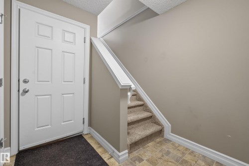 Entryway featuring a paneled door, neutral wall tones, and patterned tile flooring - 53 3625 144 Avenue, Edmonton, AB 