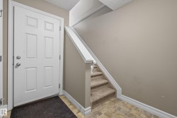 Entryway featuring a paneled door, neutral wall tones, and patterned tile flooring - 