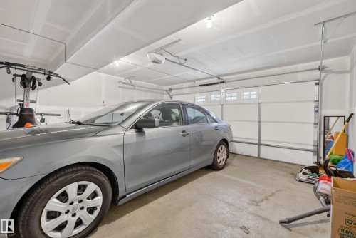 Spacious garage featuring a concrete floor, white walls, and bright overhead lighting - 53 3625 144 Avenue, Edmonton, AB 