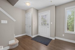 Entryway featuring wood-finish flooring, a six-panel door, and a window with blinds - 