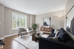 Spacious living area featuring wood-finish flooring, a large window with blinds, and recessed lighting - 