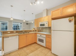 Kitchen featuring wood cabinetry, integrated microwave, built-in oven, and a double basin sink - 
