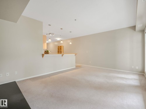 Spacious living area featuring light-colored carpeting and neutral wall tones - 150 4827 104A Street, Edmonton, AB 