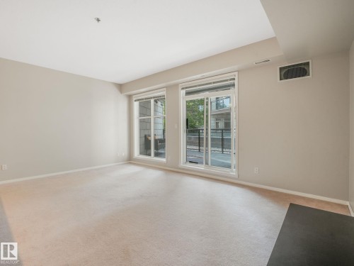 Expansive living area featuring light-toned carpeting and neutral wall paint - 150 4827 104A Street, Edmonton, AB 