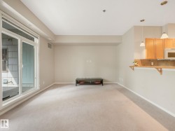 Open concept living area with light-toned carpeting and neutral wall paint - 