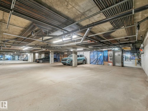 Concrete flooring and exposed overhead utilities characterize this subterranean parking area - 150 4827 104A Street, Edmonton, AB 