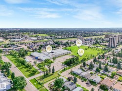 Aerial perspective showcasing a developed neighborhood with residential properties, commercial structures, and green spaces - 