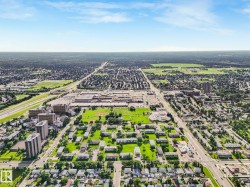 Aerial perspective showcasing a mixed-use district with low-rise and high-rise residential buildings, commercial structures, and extensive green spaces - 