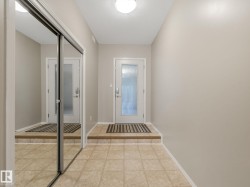 Foyer featuring ceramic tile flooring, neutral wall paint, and a white entry door with frosted glass - 