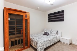 Dedicated sauna space featuring a wood-frame enclosure with a glass door - 