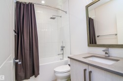 Modern bathroom featuring a contemporary vanity with a chrome faucet, undermount sink, and light-toned countertop - 