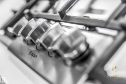 Stainless steel gas cooktop with heavy-duty grates and four control knobs - 