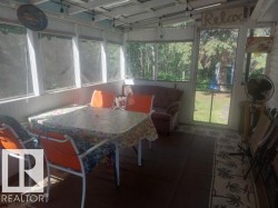Screened porch featuring wood-finish flooring, a white paneled ceiling, and multiple windows - 