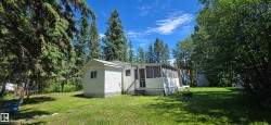 Exterior featuring white siding, a screened porch, and a gravel driveway - 